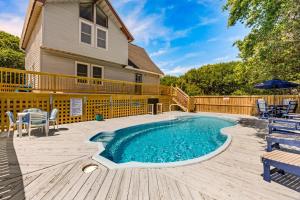 a patio with a swimming pool and a wooden deck at 4068 - Family Tradition in Kitty Hawk