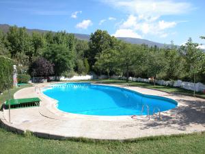 a large blue swimming pool in a yard at Camping El Balcon de Pitres in Pitres