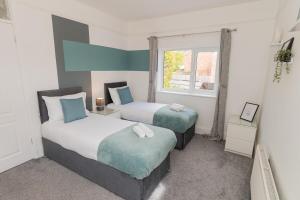 a bedroom with two beds and a window at Woodington House in Birmingham