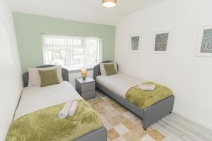 a bedroom with two beds and a window at Blackthorne House in Walsall