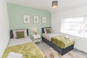 a bedroom with two beds and a window at Blackthorne House in Walsall