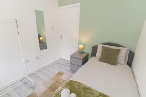 a small bedroom with a bed and a mirror at Blackthorne House in Walsall +21 photos