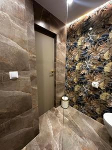 a bathroom with a wall mural of flowers at Apartament KAJA in Malbork +17 photos