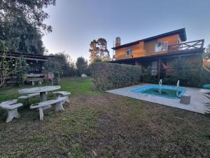 a backyard with a picnic table and a swimming pool at El Encuentro in Sierra de los Padres