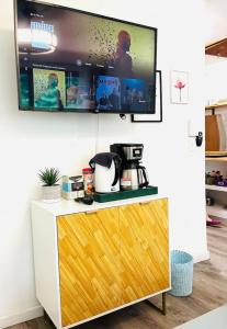 a tv on a wall above a counter with a coffee maker at Catskills The Bohemian Dream in Shandaken