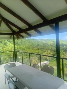 ein Tisch und Stühle in einem Zimmer mit Aussicht in der Unterkunft Sky view in Savusavu