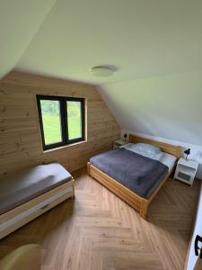 a bedroom with two beds and a window at Lasóweczka in Lasowka