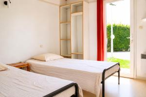 two beds in a room with a window at Chalet Mauzac- Piscine- Domaine Paisible in Rivières