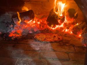 a pizza is cooking in a brick oven at Villa pamplemousse in Banī ‘Aţāʼ