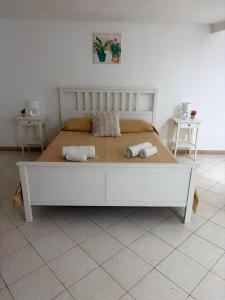a white bed in a room with two towels on it at Casa Mediterraneo in Catania