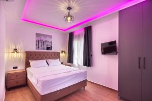 a bedroom with a bed with a pink lighting at Villa President 2 in Kunjići +34 photos