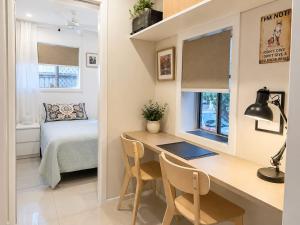 a small room with a desk and a bed at William's on William - Stylish 2 Bedroom Haven in Ormiston