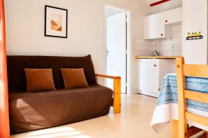 a living room with a brown couch and a kitchen at Chalet Mauzac- Piscine- Domaine Paisible in Rivières +3 photos