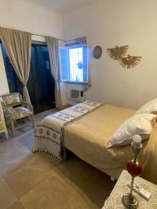 a bedroom with a bed and a chair and a window at La Casona de Emilia in Corrientes