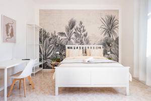 a bedroom with a white bed with a tropical wallpaper at Ethos Guest House in Quarto dʼAltino +110 photos