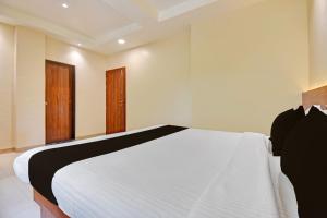 a bedroom with a white bed and two windows at Hotel O RVC GRAND CENTRAL in Viman Nagar +21 photos