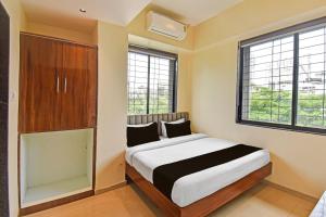 a bedroom with a bed and a large window at Hotel O RVC GRAND CENTRAL in Viman Nagar