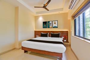 a bedroom with a bed and a ceiling fan at Hotel O RVC GRAND CENTRAL in Viman Nagar