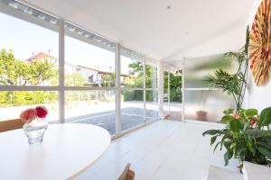 a living room with a white table and large windows at Ethos Guest House in Quarto dʼAltino