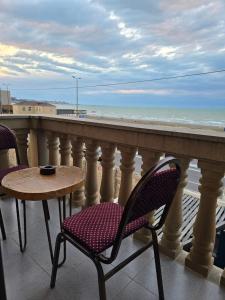 a balcony with a table and chairs and the ocean at NovArt Gallery Hotel in Sumqayıt