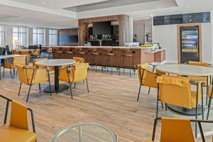a restaurant with tables and chairs and a bar at Courtyard by Marriott Woodland in Woodland