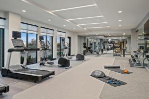 a gym with treadmills and exercise equipment and windows at Courtyard by Marriott Woodland in Woodland