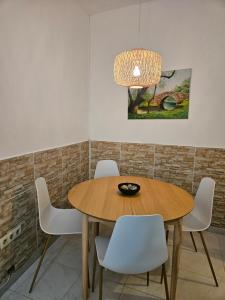 a dining room with a wooden table and white chairs at Casa A Beira do Mar in O Grove