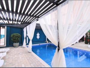 a swimming pool with white curtains over it at NovArt Gallery Hotel in Sumqayıt +42 photos