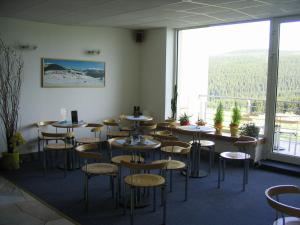 a room with tables and chairs and a large window at ALMET štúdio 404 in Donovaly