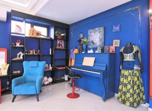 a blue room with a blue piano and a blue chair at NovArt Gallery Hotel in Sumqayıt