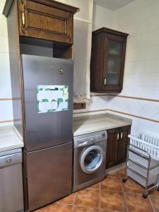 a kitchen with a refrigerator and a washing machine at Agradable Chalet con piscina en Villaharta in Villaharta