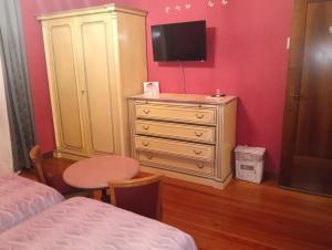 a bedroom with a dresser with a tv on top of it at Casa Degli Amici in Treviso +8 photos