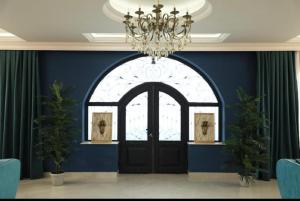 a blue room with a black door and a chandelier at NovArt Gallery Hotel in Sumqayıt