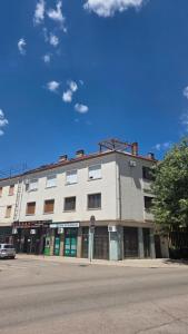 a white building on the corner of a street at Square View Apartment Center Niksic in Nikšić