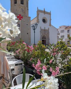 a group of tables with flowers in front of a building at Hotel República Boutique Hotel in Tomar