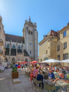 a group of people sitting at tables in front of a building at Le Salon des Voyageurs - Appartement Climatisé avec Terrasse et Parking Gratuit à Proximité in Dole