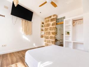 a bedroom with a bed and a flat screen tv at Latidos del mar in Denia +22 photos