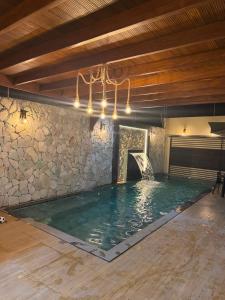 a indoor swimming pool with a stone wall at Casa Pé no Sal in Salinópolis