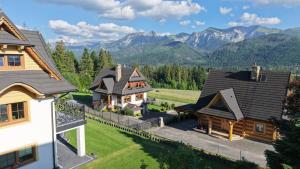 an aerial view of a house with mountains in the background at Tatra Lodge Apartamenty z widokiem na góry in Kościelisko