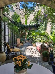 an outdoor patio with tables and chairs and plants at Chambre d'hôte Maison Magda in Beaucaire
