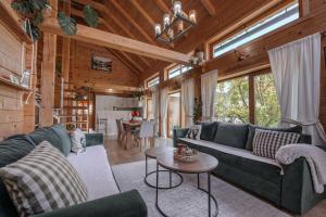 a living room with blue couches and a table at Monte Chalet Kolašin brvnara sa saunom in Kolašin