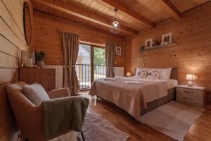 a bedroom with a bed and a chair in a cabin at Monte Chalet Kolašin brvnara sa saunom in Kolašin