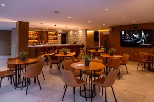 a restaurant with tables and chairs and a bar at Champet Boutique Hotel in Campos do Jordão