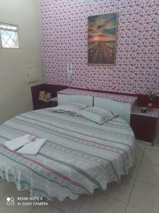 ein Schlafzimmer mit einem Bett und einer gemusterten Wand in der Unterkunft Hostel um espaço perfeito para seu descanso in Cianorte
