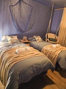 a bedroom with two beds and a net at Check in Silence in Tylicz