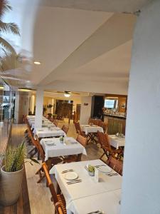a restaurant with white tables and wooden chairs at Juquehy La Plage Hotel in Juquei +79 photos