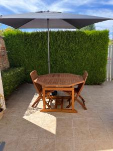 a wooden table with an umbrella on a patio at la MAISON de SEVERINE in Abbeville