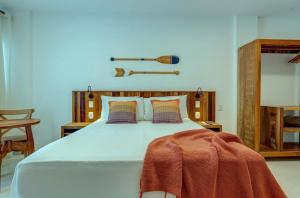 a bedroom with a large bed with a blanket on it at Cairé Suites in Itacaré