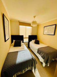 a room with two beds in it with a window at Bello y acogedor departamento 2D in Los Ángeles