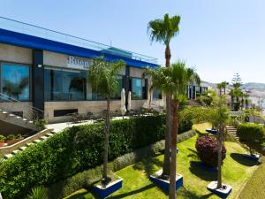 a building with palm trees in front of it at Mira Palace Hotel in Al Hoceïma +39 photos